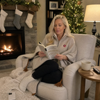Reading by the fireplace in the Snugloo heated blanket